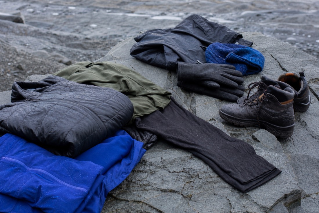 Winter thermal layers, gloves and waterproof hiking boots laid out for an Iceland ice cave tour